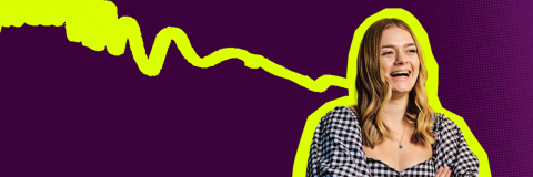 A picture of a girl looking off camera and laughing. The background is dark purple.